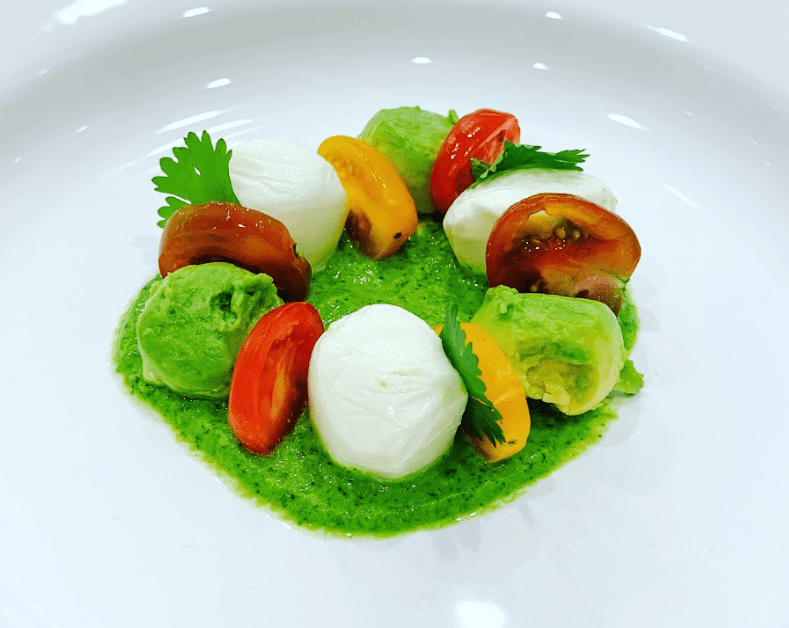 Ensalada de Tomate, Aguacate, y Queso Mozzarella en una cama de Vinagreta de Cilantro